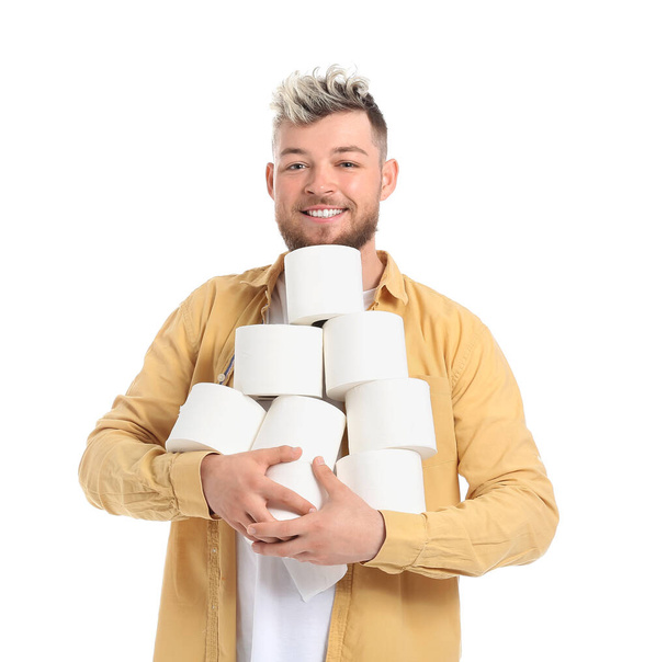 Jeune homme avec de nombreux rouleaux de papier toilette sur fond blanc - Photo, image