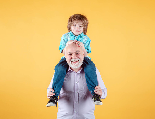 Grandfather and grandson piggy back ride with funny face isolated. Elderly old relative with child. - Фото, зображення