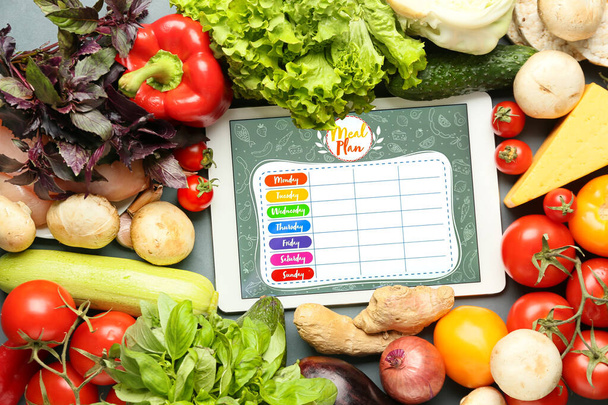 Tablet computer with meal plan and healthy products on grey background - Photo, Image