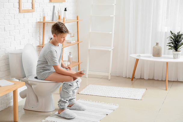 Little boy out of toilet paper in bathroom - Foto, Imagen