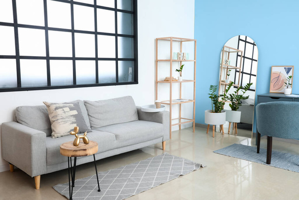 Moderne Wohnzimmereinrichtung mit stilvollem Spiegel und Sofa - Foto, Bild