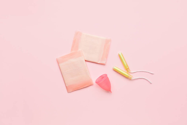 Coupe menstruelle, tampons et tampons sur fond rose - Photo, image