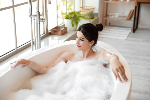 Entspannte junge Frau badet zu Hause - Foto, Bild