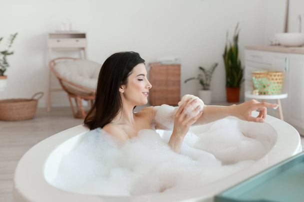 Entspannte junge Frau badet zu Hause mit Luffa - Foto, Bild