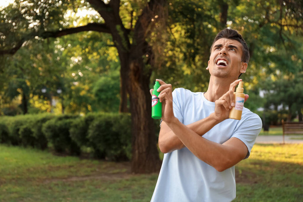 Молодий чоловік з москітними репелентами на відкритому повітрі
 - Фото, зображення