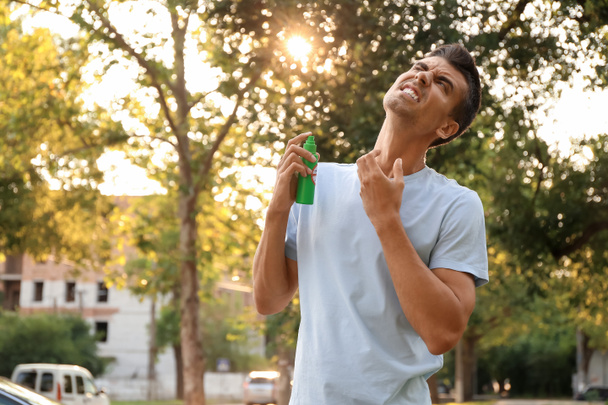 Молодой человек с противомоскитными средствами на открытом воздухе - Фото, изображение