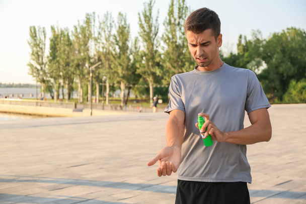 Молодой человек с противомоскитными средствами на открытом воздухе - Фото, изображение