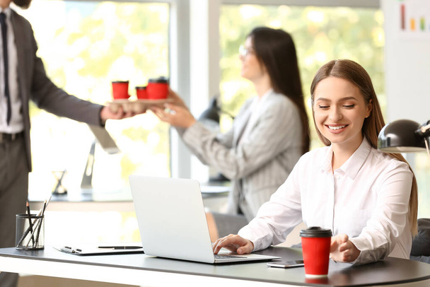 Jovem mulher fazendo coffee break no escritório
 - Foto, Imagem