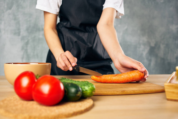 黒エプロンの女性料理健康的な食事サラダダイエット - 写真・画像