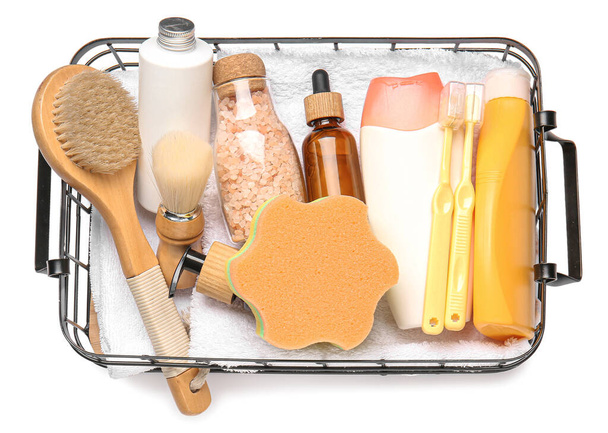 Корзина с принадлежностями для ванны, полотенцем и губкой на белом фоне - Фото, изображение
