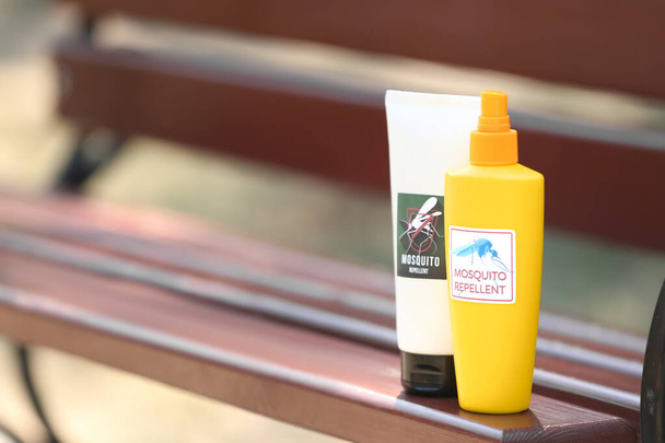Repelente de mosquito spray e creme no banco ao ar livre - Foto, Imagem