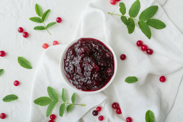 Composition with tasty cranberry jam and fresh berries on white background - Foto, imagen