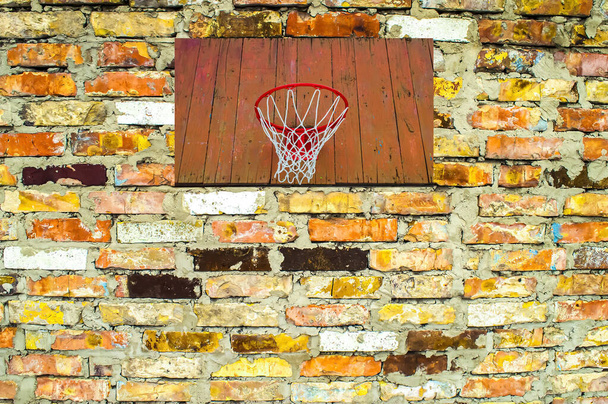 Plecak do koszykówki z pierścieniem na ścianie z cegły. - Zdjęcie, obraz