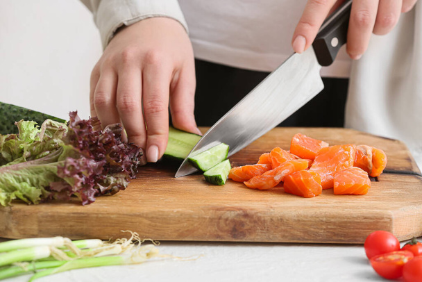 Nainen leikkaa tuoreita vihanneksia salaattia pöydälle, lähikuva - Valokuva, kuva