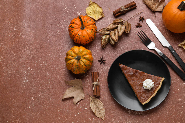 Осенняя композиция с кусочком вкусного тыквенного пирога на цветном фоне - Фото, изображение