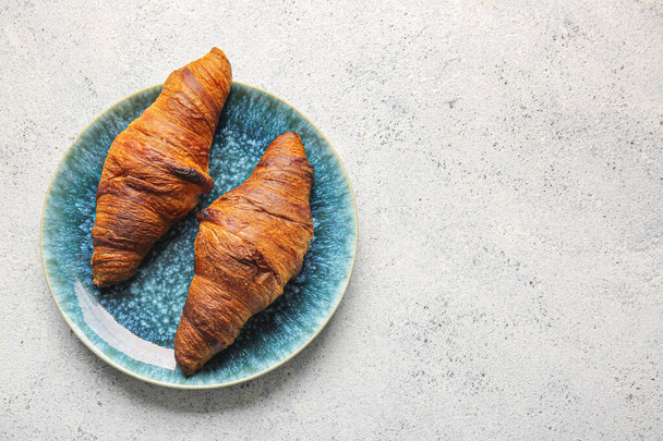 Plate with tasty croissants on light background - Photo, Image