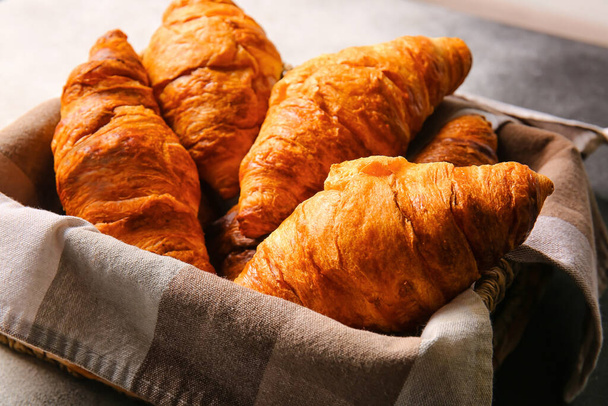 Basket with delicious croissants on table - Photo, Image