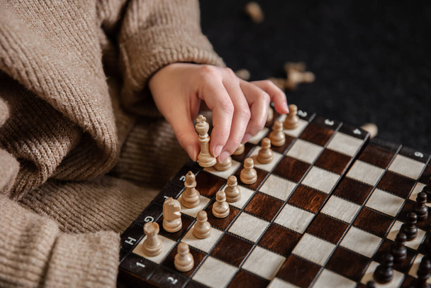 Nainen, joka asettaa shakkinappuloita shakkilautaan. - Valokuva, kuva