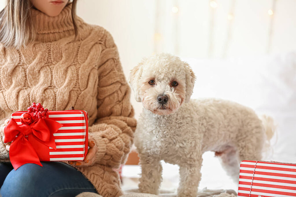 Γυναίκα με χαριτωμένο σκυλί και δώρα Χριστουγέννων στην κρεβατοκάμαρα - Φωτογραφία, εικόνα