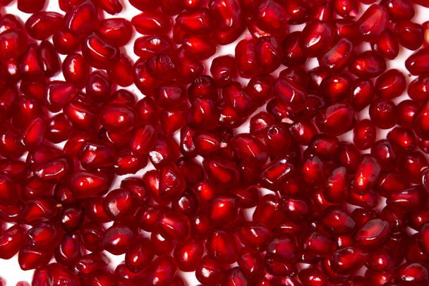 Pomegranate seeds on a white background. Peeled pomegranate in full screen. - Фото, изображение