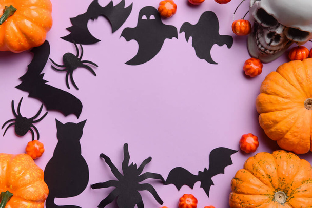 Frame made of Halloween decor and pumpkins on violet background - Photo, Image