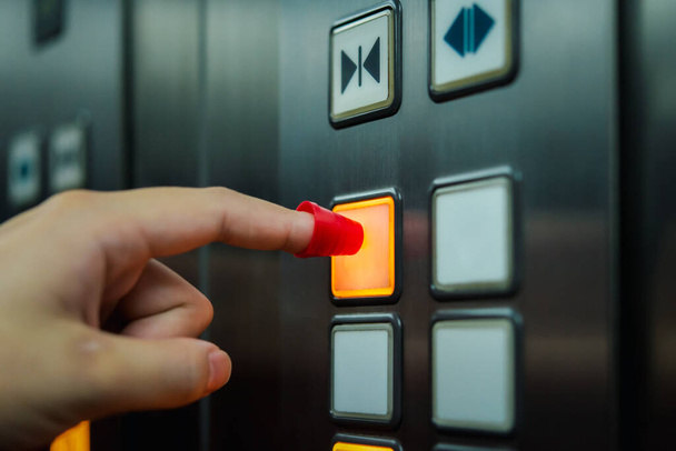 Люди надевают щит при нажатии кнопки в лифте для защиты от эпидемии гриппа covid19 или коронного вируса со страхом эмоций в концепции болезни, вспышки, здравоохранения в жизни - Фото, изображение