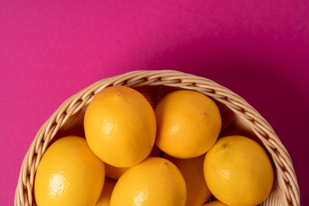 Ripe lemons on bright pink paper background - Foto, Imagen