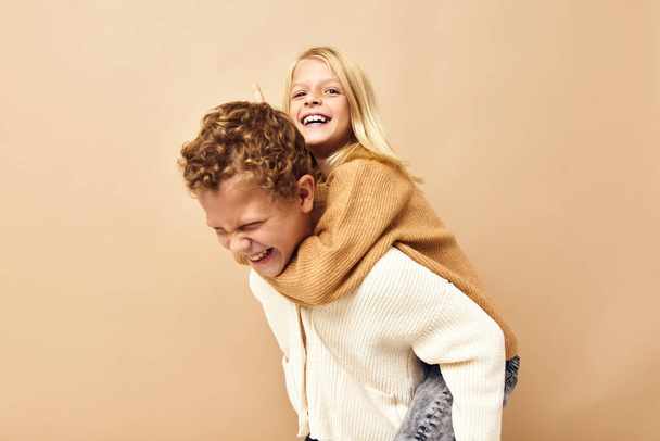 jongen en meisje leuk mode jeugd stijlvol - kleding jeugd beige achtergrond - Foto, afbeelding