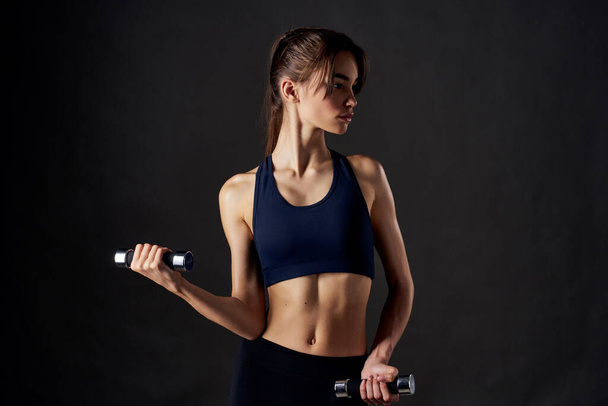 pretty woman fitness exercise dumbbells in the hands of Strong isolated background - Photo, Image