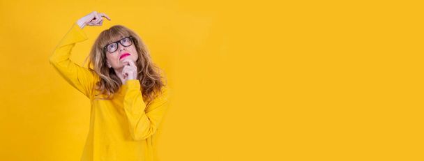 adult woman thinking isolated on yellow - Fotografie, Obrázek