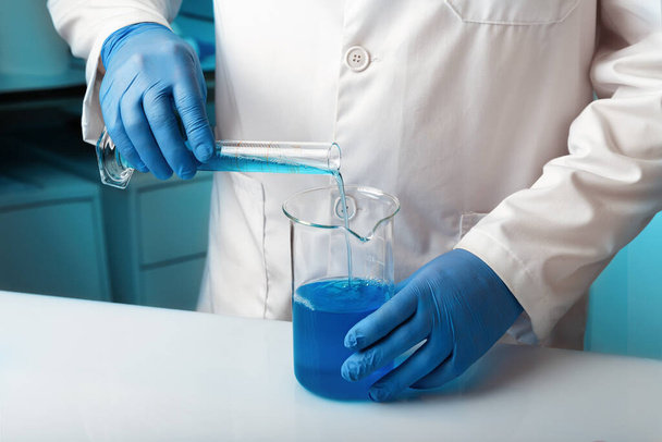 化学研究室で流体を混合するためのチューブを扱う研究者。液体を用いた化学実験の開発を行う研究室の研究者 - 写真・画像