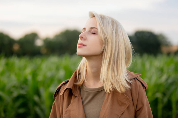 Blonde woman in cloak in cornfield in summertime - Photo, Image