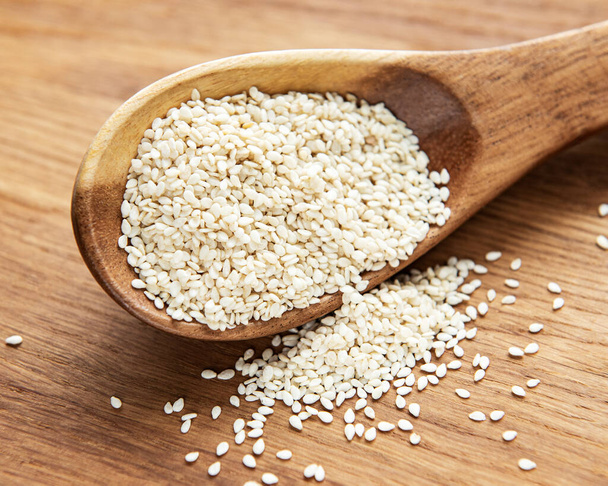 Healthy food and drink concept. Sesame seeds in a spoon on a rustic table - Photo, image