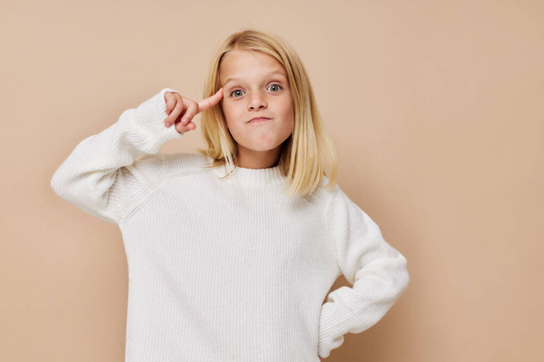 Positive little girl talking on the phone technology on a beige background - 写真・画像