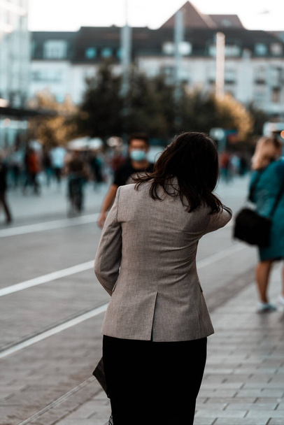 A vertical shot of the woman walking in the street. - Fotó, kép