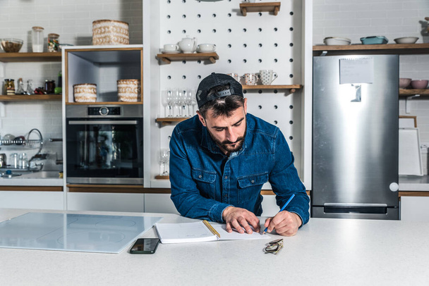 Young freelancer businessman planning and organizing business from his home. Creative man standing in the kitchen getting ideas and solutions for new project. - Fotografie, Obrázek