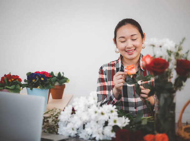 Lehren Blumenarrangements online im Haus Konzept, asiatische Frau Smiling Florist Video-Übertragung oder Kurs auf Smartphone oder Computer aufnehmen, komponieren arrangieren Blumenschmuck, Online-Blumenladen. - Foto, Bild