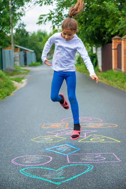 Child jumping classics on the street. Selective focus. Kid. - Фото, зображення