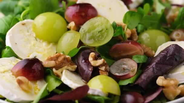 Italiaanse salade met geitenkaas, druiven en walnoten. Gezond voedsel - Video