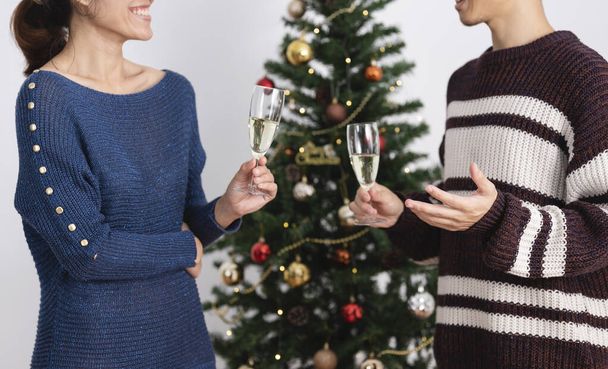Pari juhlii joululomaa yhdessä juomalasien kanssa samppanjaa joulupäivänä. - Valokuva, kuva