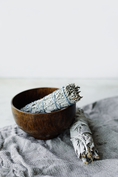 twisting dry grass white sage in a wooden cup. herb for aromatherapy and . meditation accessories. vertically, selective focus - Φωτογραφία, εικόνα