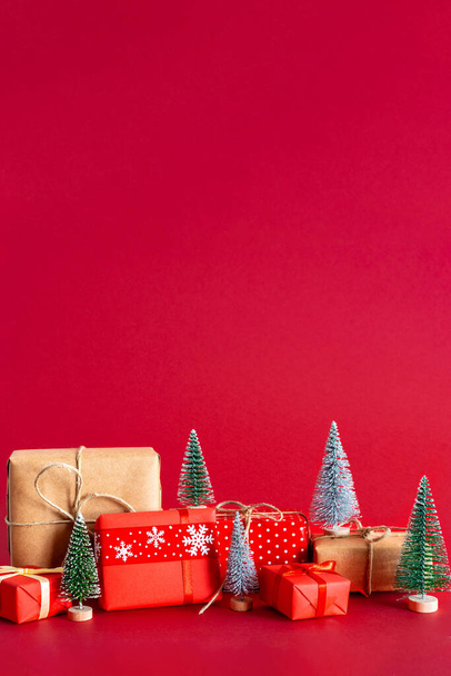 The Christmas gifts and mini pine trees isolated on red background with copy space - Valokuva, kuva