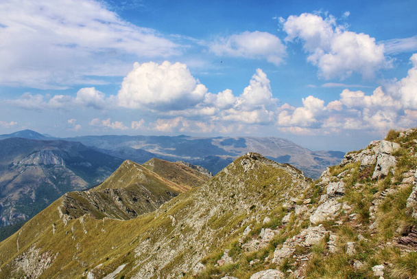 A high angle shot of an amazing landscape with mountains, blue sky and white puffy clouds. - Fotoğraf, Görsel