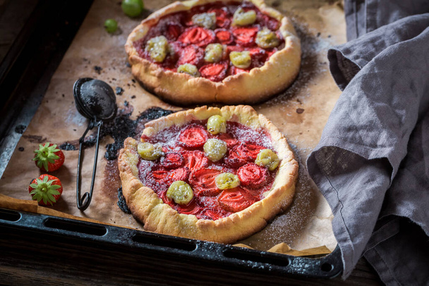 Homemade tart with gooseberries and strawberries Berries tart with sugar. Homemade berries tart in summer. - Fotografie, Obrázek