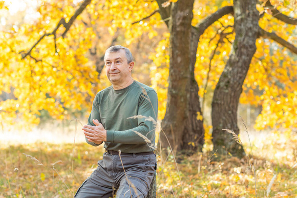 Mature European man with a good mood, outdoor portrait at autumn park . The concept of life after 50 years - Φωτογραφία, εικόνα