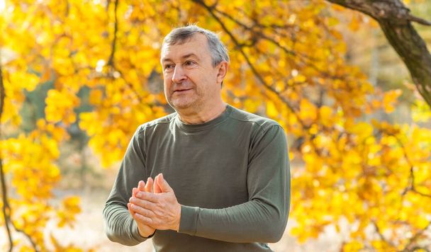 Hombre europeo maduro con un buen humor, retrato al aire libre en el parque de otoño. El concepto de vida después de 50 años - Foto, Imagen