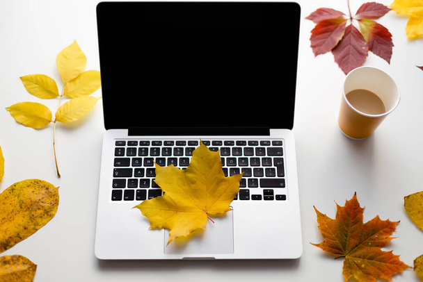 Jegyzetfüzet és őszi levelek. Sárga lap fekszik a füzetben. - Fotó, kép