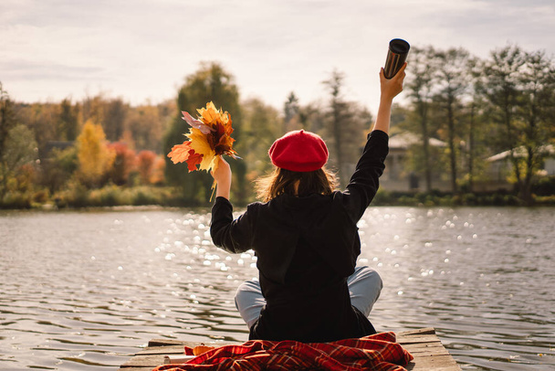 Teengirl v červeném baretu s knihou o dřevěném pontonu. Podzimní období. - Fotografie, Obrázek