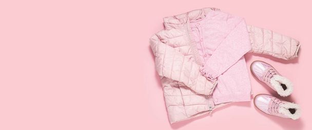 Σακάκι, μπλούζα και παιδικά μποτάκια για ένα κορίτσι σε ροζ φόντο. Πάνω άποψη, επίπεδη lay. Μπάνερ. - Φωτογραφία, εικόνα