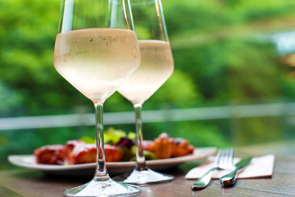 Δύο ποτήρια νόστιμα ψύχεται λευκό κρασί με σνακ στο παιχ - Φωτογραφία, εικόνα